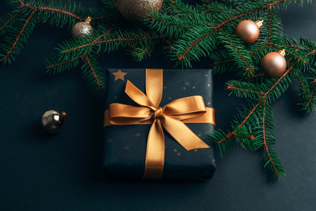 Black gift box, Christmas baubles and fir tree on black background. New Year concept. Top view, flat layの写真素材