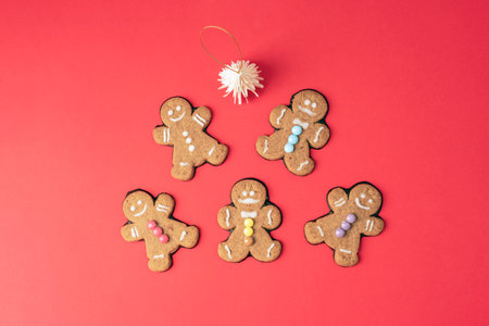 Top view of gingerbread cookies with colorful decorations and christmas ornament on red background. Top view, flat lay.の写真素材