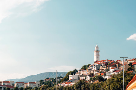 Village with red roofs and white church tower under clear blue sky. Novi Vinodolski town, Croatiaの写真素材