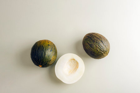 Cantaloupe melons on light green background. Top view, flat lay