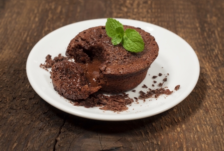 chocolate cake with mint leaves on a wooden textureの写真素材