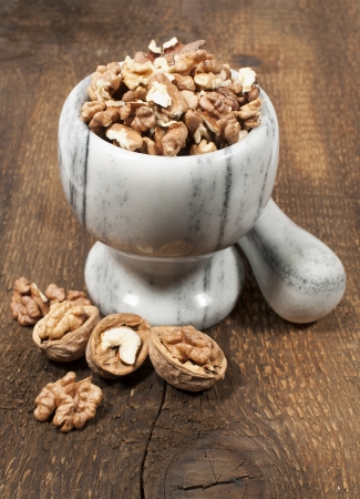 walnut kernels in a stone mortar on a wooden background
の写真素材