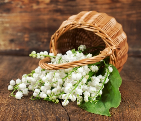 bouquet of lilies of the valley in a wicker basket on a wooden background
の写真素材