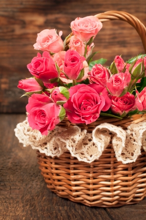 roses in a wicker basket on a wooden backgroundの写真素材
