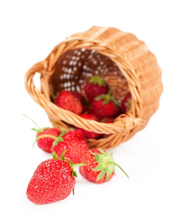 ripe strawberries in a basket isolated on whiteの写真素材