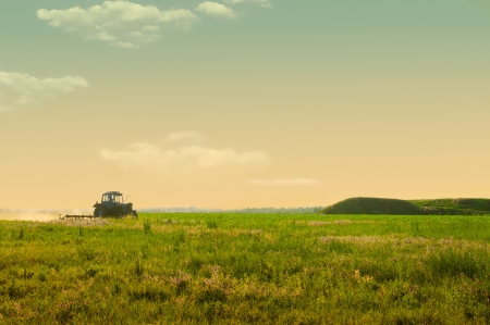 agricultural work in the field at sunsetの写真素材