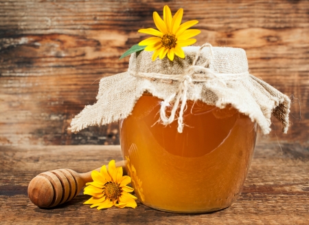 Sweet honey with yellow daisies on a wooden backgroundの写真素材