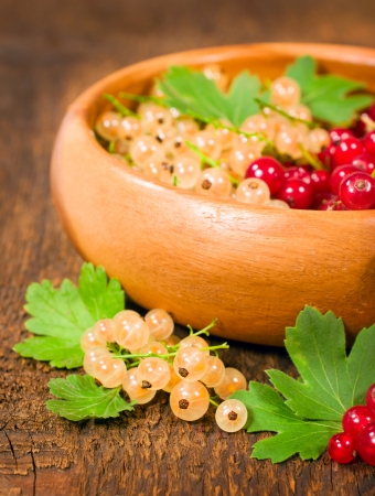 red and white currant in wooden bowl close-upの写真素材