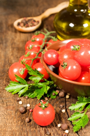 Vegetarian food  still life with fresh cherry tomatoes, parsley , olive oil and spicesの写真素材