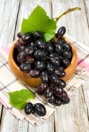red ripe grapes in a wooden bowl, close-upの写真素材