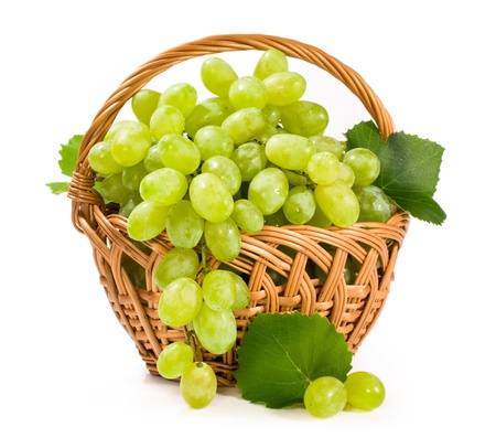 green grapes in a wicker basket isolated on whiteの写真素材