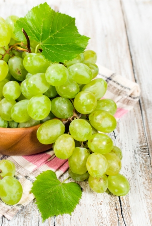fresh green grapes in a wooden bowl, close-upの写真素材
