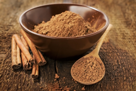 Cocoa powder and cinnamon sticks on wooden backgroundの写真素材