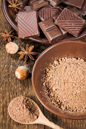 chocolate, nuts and cocoa powder on wooden backgroundの写真素材