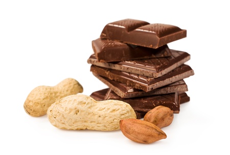 broken chocolate bar with peanuts in shell isolated on whiteの写真素材