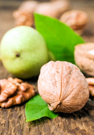 walnuts with leaves on a wooden backgroundの写真素材