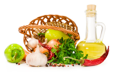 basket with vegetables and a bottle of oil isolated on whiteの写真素材