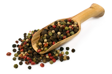 spice mix of peppers in a wooden scoop isolated on whiteの写真素材