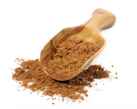 cocoa powder in a wooden scoop isolated on whiteの写真素材