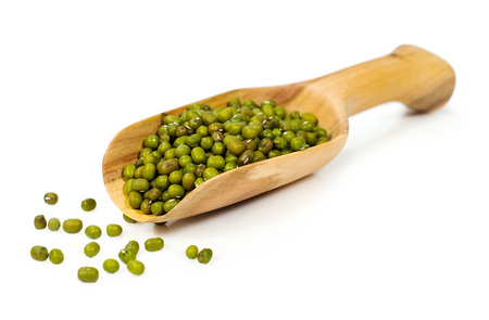 raw mung beans in a wooden scoop isolated on whiteの写真素材