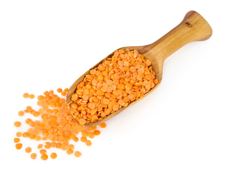 yellow lentils in a wooden scoop isolated on whiteの写真素材