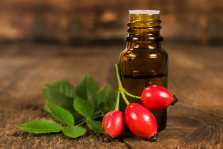 bottle of essential oil of rose hips on wooden backgroundの写真素材