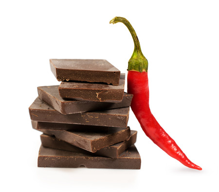 broken black chocolate with chili pepper isolated on whiteの写真素材