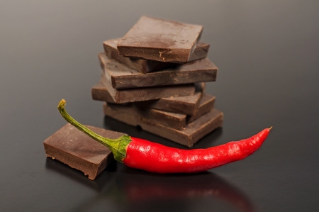 Black chocolate with red hot pepper on a dark backgroundの写真素材