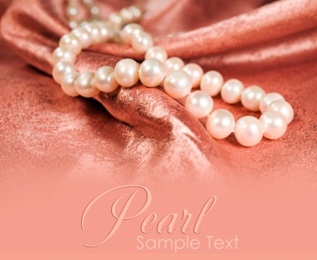 pearl necklace on a pink silk close-up with copy spaceの写真素材