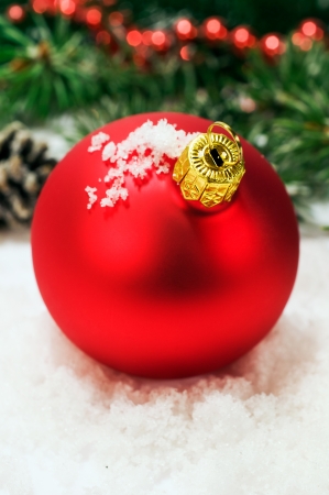 Red Christmas ball in the snow close-upの写真素材