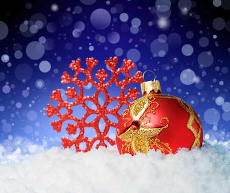 Red Christmas ball with a decorative snowflake in snowの写真素材