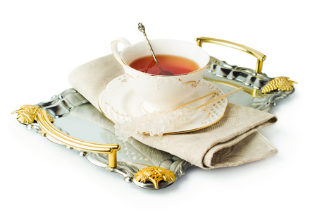 elegant tea cup on a tray with sugar on a stick isolated on whiteの写真素材
