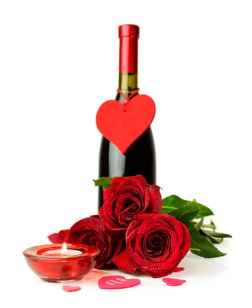 Valentine's Day. Bottle of wine , red roses and candle isolated on whiteの写真素材