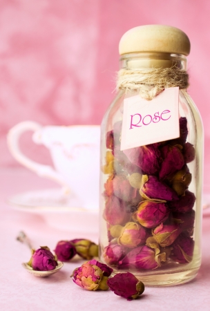 Dried rosebuds tea in a glass bottle of pink の写真素材