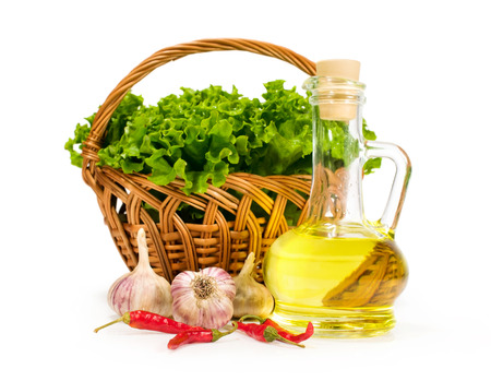 Olive oil in a bottle with fresh vegetables isolated on white backgroundの写真素材