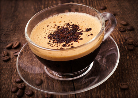 coffee with foam in glass cup on wooden backgroundの写真素材