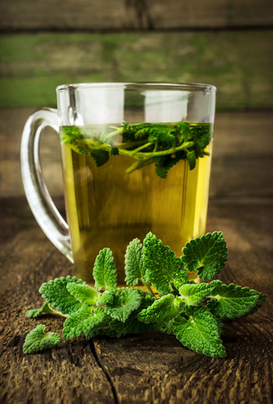 mint tea in glass cup with fresh leaves closeupの写真素材