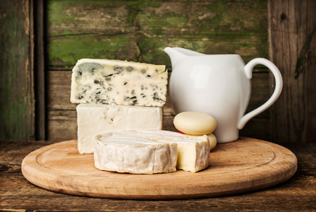 different cheeses and milk in a jug on the wooden backgroundの写真素材