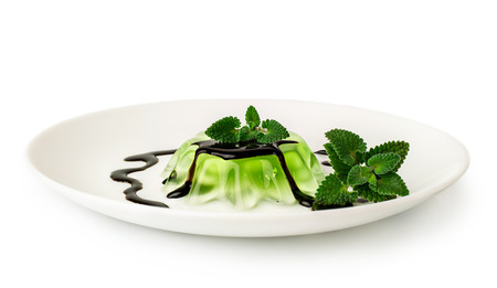 green jelly dessert with chocolate and mint isolated on whiteの写真素材