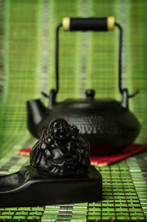 Asian tea. Black clay teapot and incense stand closeup on bamboo backgroundの写真素材