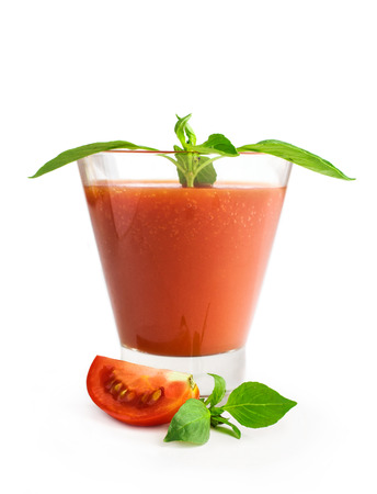 tomato juice with basil in a glass isolated on whiteの写真素材