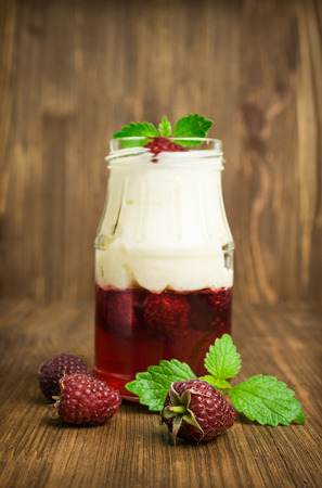 raspberry dessert with jelly and cream on a wooden backgroundの写真素材