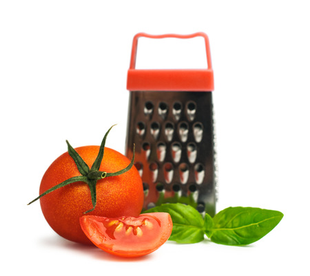 cherry tomatoes with basil and a small grater isolated on whiteの写真素材