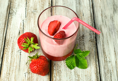 yogurt with strawberries on wooden backgroundの写真素材