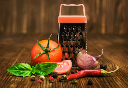 cherry tomatoes with basil, spices and small grater on wooden backgroundの写真素材