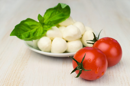 mozzarella , cherry tomatoes and basil on wooden tableの写真素材