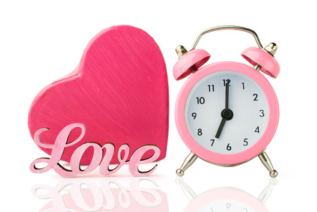 pink alarm clock and  heart shape gift box isolated on whiteの写真素材