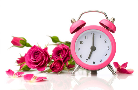 bouquet of roses and pink alarm clock isolated on whiteの写真素材