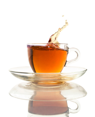 tea splash in a glass cup isolated on whiteの写真素材