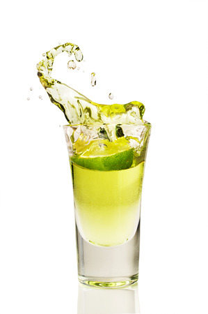 splash of tequila from the falling pieces of lime isolated on whiteの写真素材